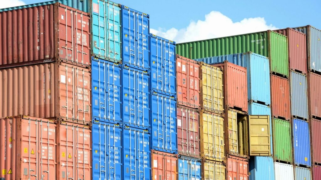 Contenedores de carga de exportación apilados en un patio portuario.